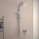 Duschsystem von Ideal Standard mit einer großen Kopfbrause und Handbrause, montiert an einer Wand. Ausgestattet mit einer Chrom-Armatur und flexiblen Schläuchen.